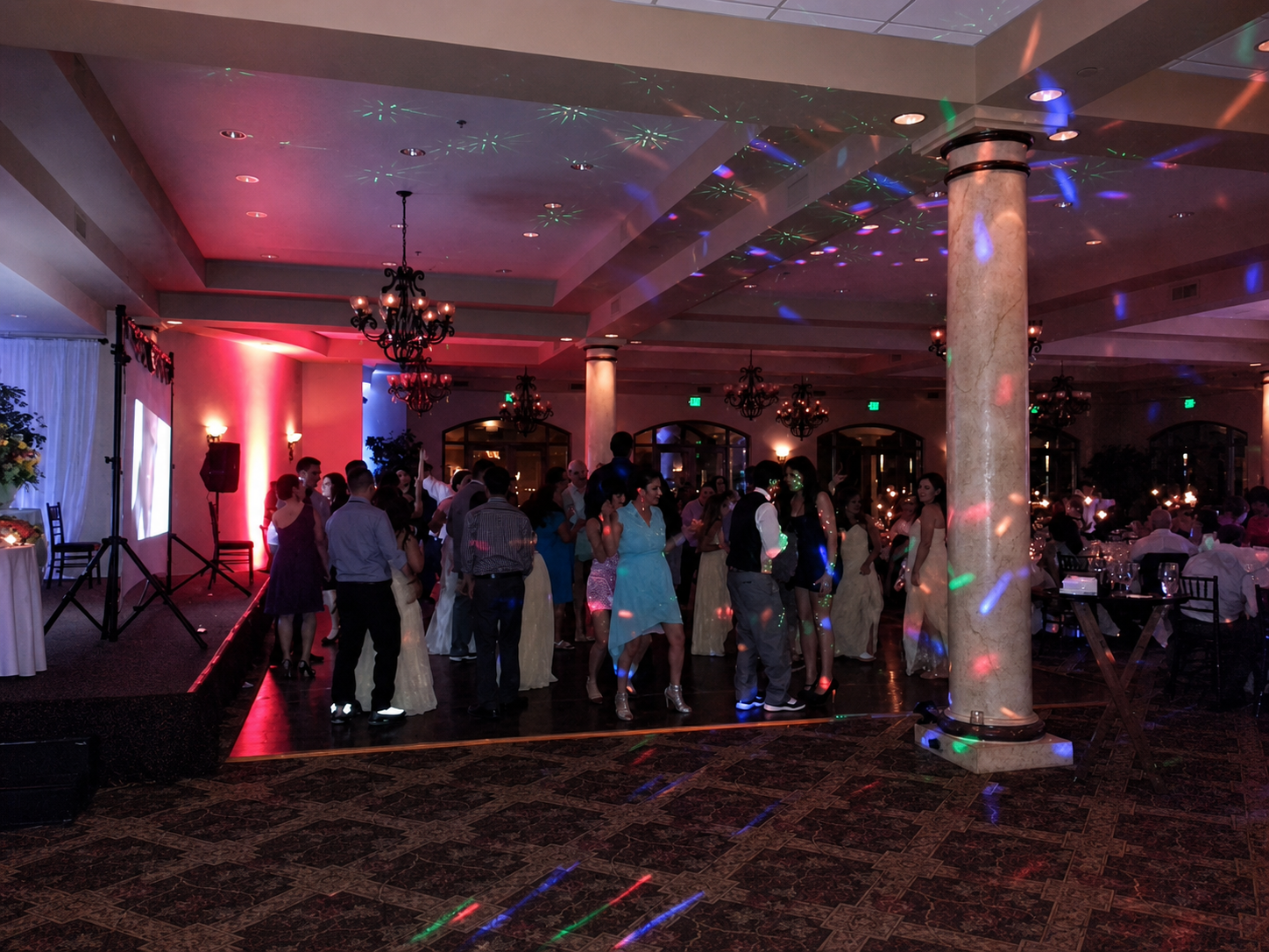 A real wedding dance floor under colorful music-reactive lighting